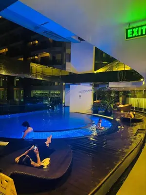 a group of people in a swimming pool at night at Prime Location Walk to Nightlife! The Gramercy in Manila