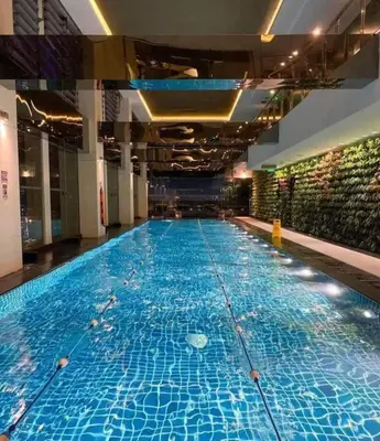 a large swimming pool with blue water in a building at Prime Location Walk to Nightlife! The Gramercy in Manila