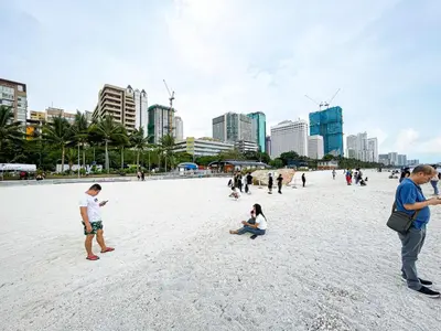 a group of people standing on a beach at Luxury Condo in Manila Bay near US Embassy in Manila