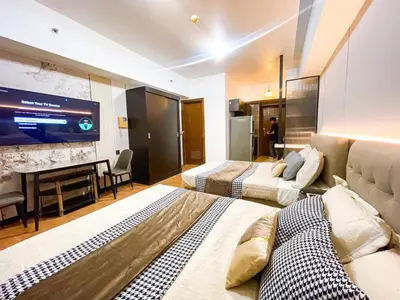 a hotel room with two beds and a flat screen tv at Luxury Condo in Manila Bay near US Embassy in Manila