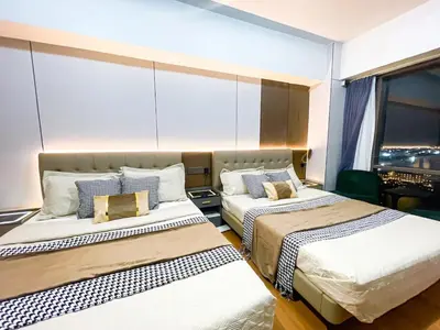 two beds in a room with a window at Stunning Sunset Retreat at Eton Bayview II 2pax in Manila