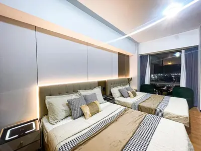 two beds in a room with a large window at Stunning Sunset Retreat at Eton Bayview II 2pax in Manila