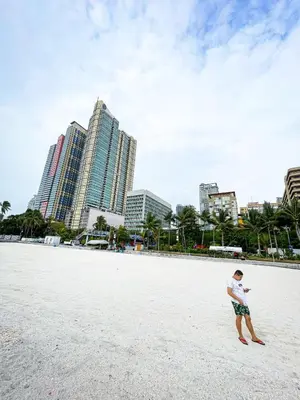 a man standing on a beach with buildings in the background at Stunning Sunset Retreat at Eton Bayview II 2pax in Manila