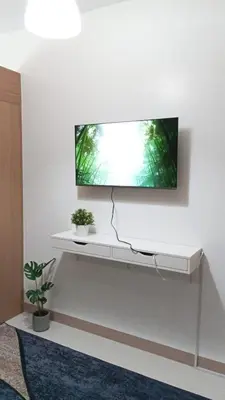 a flat screen tv on a white wall at El Aris Lushly Inn in Manila