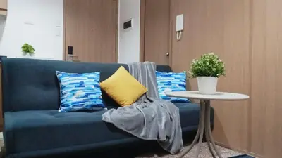a blue couch with blue and yellow pillows and a table at El Aris Lushly Inn in Manila