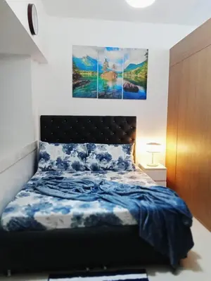 a bedroom with a bed with a blue comforter at El Aris Lushly Inn in Manila