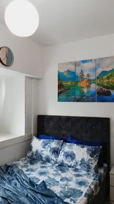 a bed in a bedroom with three paintings on the wall at El Aris Lushly Inn in Manila