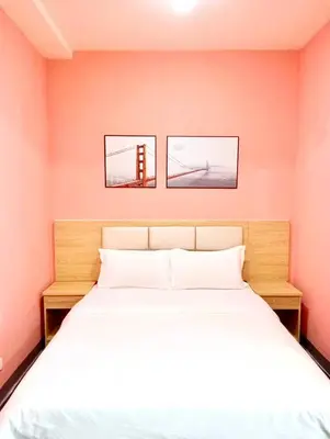 a bedroom with a bed with two pictures on the wall at La Chicka Staycation in Coast Residences in Manila