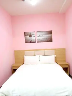 a bedroom with a white bed and two pictures on the wall at La Chicka Staycation in Coast Residences in Manila