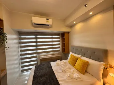 a bedroom with a bed with yellow pillows and a window at Deluxe Room with Parking in Red Residences Chino Roces Ave, Makati by Prime Stay in Manila