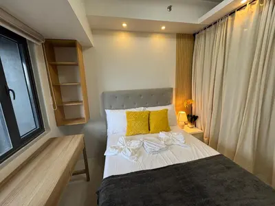 a bedroom with a bed with yellow pillows and a window at Deluxe Room with Parking in Red Residences Chino Roces Ave, Makati by Prime Stay in Manila