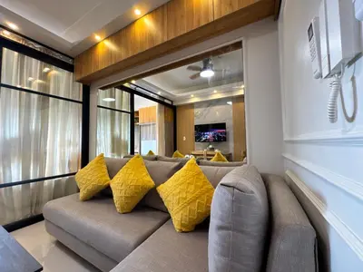 a living room with a couch with yellow pillows at Deluxe Room with Parking in Red Residences Chino Roces Ave, Makati by Prime Stay in Manila