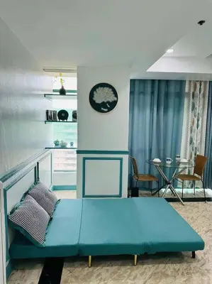 a bedroom with a blue bed and a table at Sea View Condo in Manila