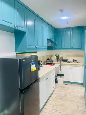 a kitchen with blue cabinets and a refrigerator at Sea View Condo in Manila