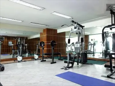 a gym with several treadmills and machines in a room at Sea View Condo in Manila