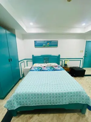 a bedroom with a bed with a blue bedspread at Sea View Condo in Manila