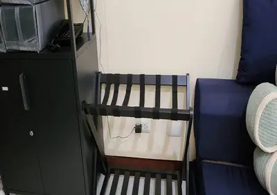a small room with a bed next to a cabinet at Owls and Larks BnB 300mbps WiFi, Netflix, Coffee in Manila