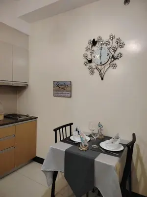 a table in a kitchen with a clock on the wall at Owls and Larks BnB 300mbps WiFi, Netflix, Coffee in Manila