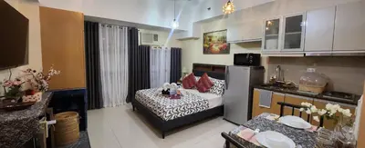 a living room with a bed and a kitchen with at Owls and Larks BnB 300mbps WiFi, Netflix, Coffee in Manila