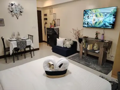 a living room with a bed and a dining room at Owls and Larks BnB 300mbps WiFi, Netflix, Coffee in Manila