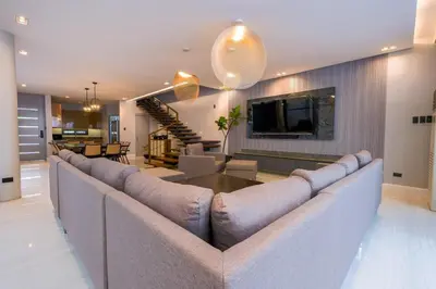 a living room with a long couch and a television at Casa Bonifacio by JC in Manila