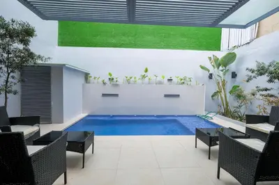 a pool in a room with tables and chairs at Casa Bonifacio by JC in Manila