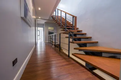 a hallway with wooden stairs in a house at Casa Bonifacio by JC in Manila