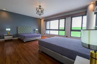 a bedroom with two beds and two windows at Casa Bonifacio by JC in Manila
