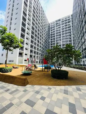 a park in a city with two tall buildings at La Deza Shore 2 Residences Pasay Manila in Manila