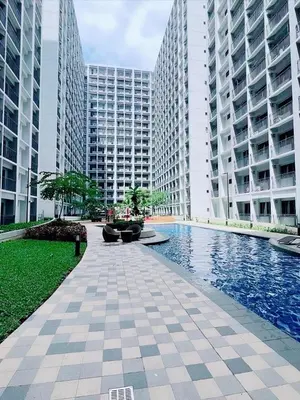 a pool in the middle of two tall buildings at La Deza Shore 2 Residences Pasay Manila in Manila