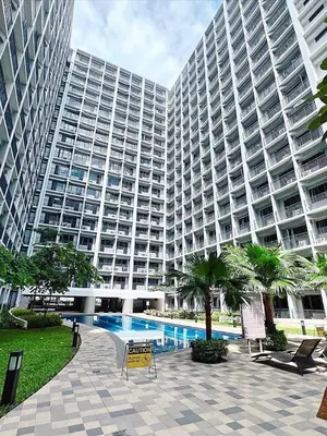 a large building with a swimming pool in front of it at La Deza Shore 2 Residences Pasay Manila in Manila
