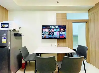 a room with a table and chairs and a television at La Deza Shore 2 Residences Pasay Manila in Manila
