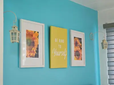 a row of framed pictures on a blue wall at CondoDeal at Shell Residences Mall of Asia in Manila