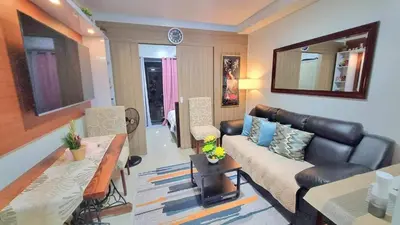 a living room with a couch and a table at MOA Exquisite Suite Manila by JAO's Staycation in Manila