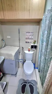 a small bathroom with a toilet and a bed at MOA Exquisite Suite Manila by JAO's Staycation in Manila