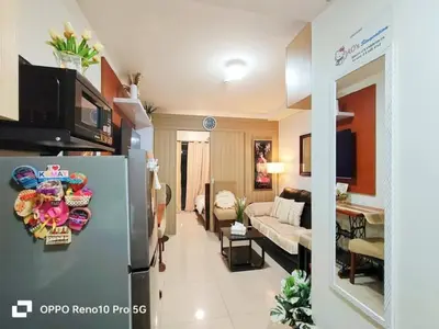 a living room with a couch and a refrigerator in a room at MOA Exquisite Suite Manila by JAO's Staycation in Manila