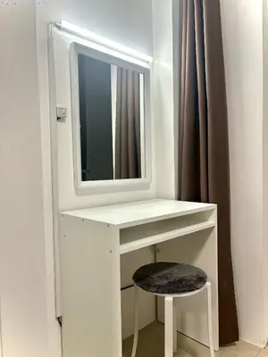 a white dressing table with a mirror and a stool at New Oasis Staycation Shore 1 in Manila