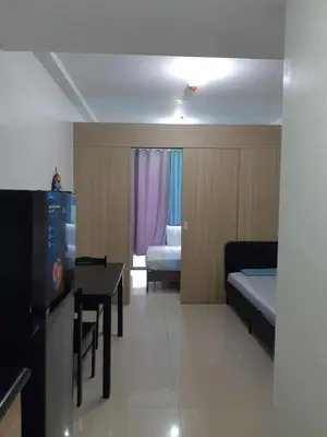 a room with a television and a bed and a table at Shore 2 tower 1 in Manila