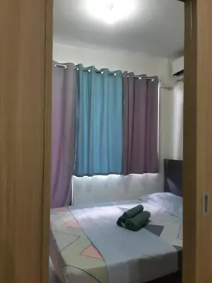 a bedroom with a bed with colorful curtains at Shore 2 tower 1 in Manila