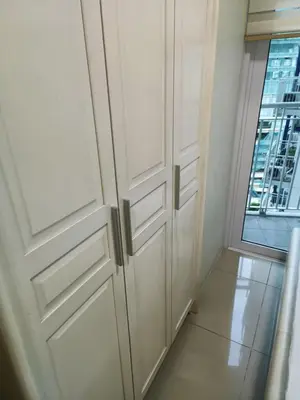 a room with white cabinets and a window at Homey 1 Bedroom Condo with Blacony and Wifi in Manila