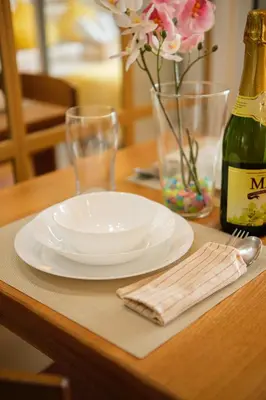 a white plate on a table with a bottle of wine at Azure Urban Resort Residences Parañaque City in Manila