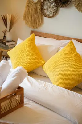 two yellow pillows sitting on top of a bed at Azure Urban Resort Residences Parañaque City in Manila