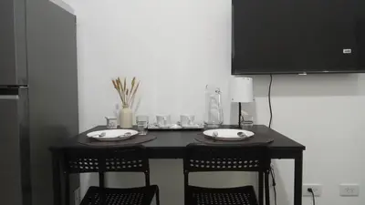 a small table with two chairs and a television at 642 - Quiet & secured condo in Cavite with HI speed WIFI in Dasmariñas