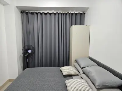 a bed in a room with a gray curtain at 642 - Quiet & secured condo in Cavite with HI speed WIFI in Dasmariñas