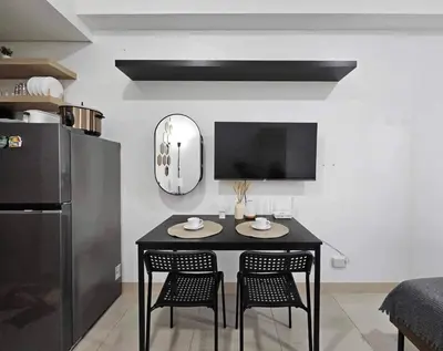 a kitchen with a black table and chairs in a room at 642 - Quiet & secured condo in Cavite with HI speed WIFI in Dasmariñas