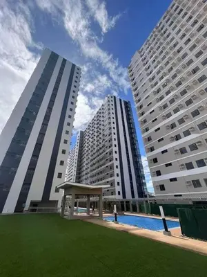 two tall buildings with a bench in the middle of a park at 642 - Quiet & secured condo in Cavite with HI speed WIFI in Dasmariñas