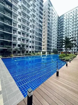 a swimming pool in front of a large apartment building at Crystal Cove by Casa Stellar Mall of Asia Complex in Manila