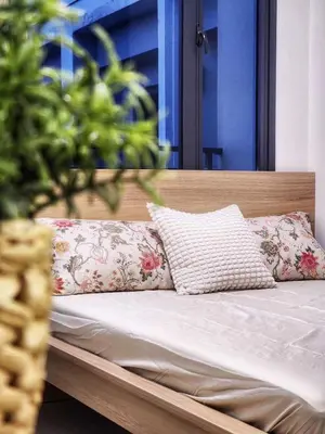 a bed with pillows on it with a wooden headboard at Crystal Cove by Casa Stellar Mall of Asia Complex in Manila