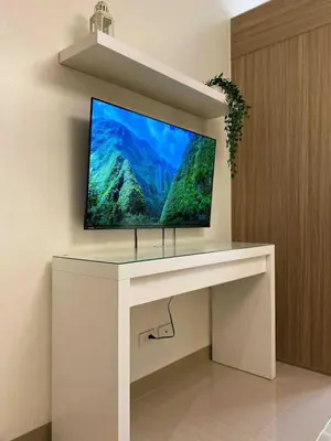 a tv sitting on top of a white desk at Crystal Cove by Casa Stellar Mall of Asia Complex in Manila