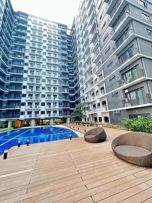 a courtyard with two benches and two tall buildings at Crystal Cove by Casa Stellar Mall of Asia Complex in Manila